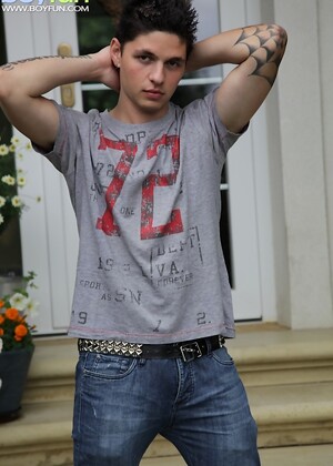 Tattooed stud Jeremy stroking his cock outdoors.